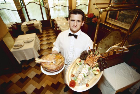 法国benoit餐馆的服务员端来烹饪好的菜肴